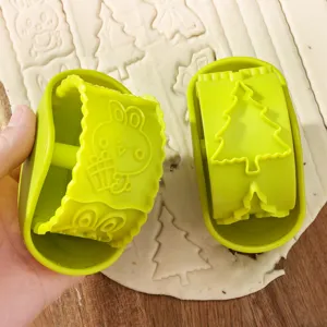 Green plastic rolling cookie cutters with cute bunny and Christmas tree embossing designs.