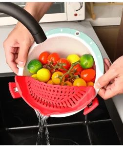 Dettaglio scolapasta in silicone per bordo pentola che filtra cibi nel lavandino cucina.