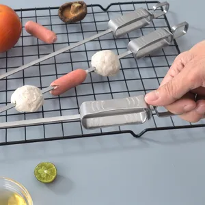 Stainless steel BBQ skewers with sliding pusher tool for outdoor grilling and kitchen use.