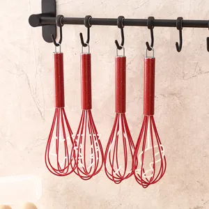 Frusta da cucina in acciaio inossidabile manuale con manico rosso per la cottura domestica.