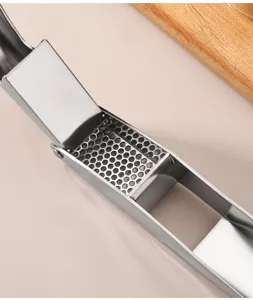 Stainless steel garlic press detail shot, durable kitchen tool for easy garlic mincing.