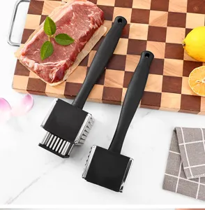 Stainless steel meat tenderizer tool detail shot, black handle kitchen mallet for steak cooking.