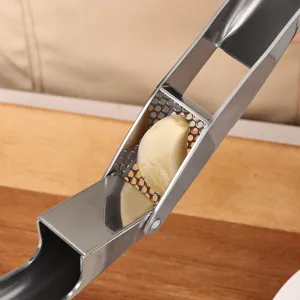 Heavy duty stainless steel garlic press kitchen tool for easy garlic mincing and crushing.