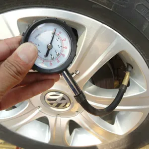 Mechanical tire pressure gauge with flexible hose and deflation valve for accurate car tire tests.