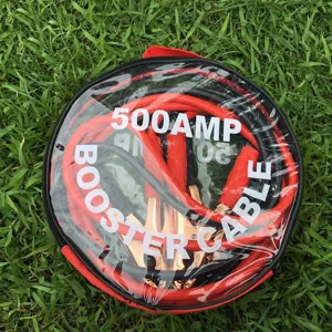 Detailaufnahme von 500AMP Starthilfekabeln ordentlich aufgerollt in einer klaren Tasche im Gras.