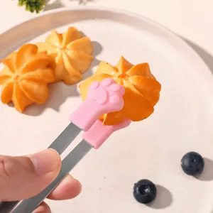Stainless steel ice tongs with cute silicone cat paw grip for serving sugar cubes and pastries.