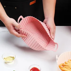 Pink foldable silicone air fryer basket liner non-stick baking pan with handles for cooking.