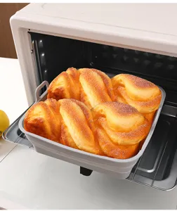 Detailansicht eines quadratischen grauen Silikon-Faltbackblechs mit Brot im Ofen der Küche.
