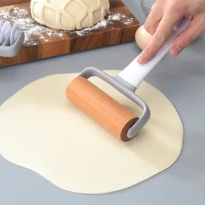 Handgeführtes Holz-Teigroller und Teigschneider-Werkzeug für das Backen in der Küche.
