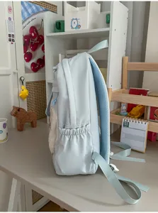 Hellblauer College Stil Schulrucksack Seitenansicht mit Seitentasche und transparentem Frontfach.
