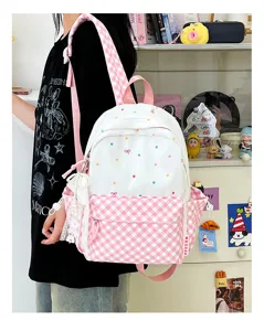 Rosa Karo und gepunkteter Rucksack für Schülerinnen mit Anhänger und Vordertasche.