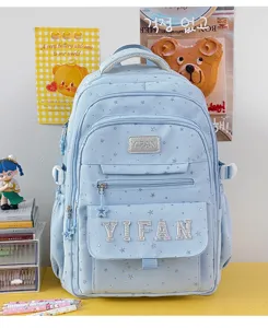 Detaillierte Nahaufnahme des süßen blauen Stern-Schulrucksacks mit glitzernden Buchstaben.