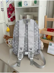 Nahaufnahme der grauen Rucksack-Rückenriemen mit Sternenmuster und Schnallen im Zimmer.