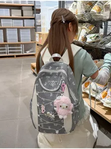 Schwarzer und weißer Karo-Rucksack Schultasche mit niedlichem Plüschanhänger für Studenten.