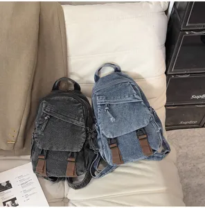 Detail van de vintage denim rugzak met meerdere zakken, dubbele gespen en bandjes.
