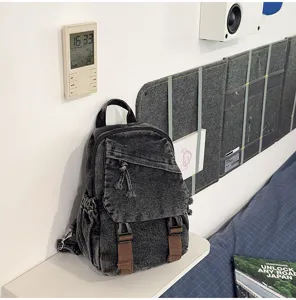 Gedetailleerd overzicht van een retro verwassen denim rugzak met unieke bruine riemaccenten.