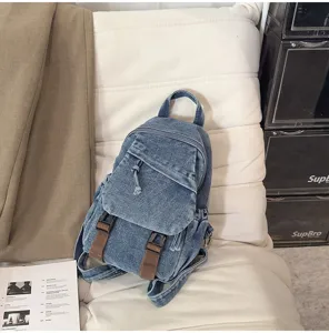Gedetailleerd uitzicht op vintage gewassen denim mini-rugzak met bruine bandjes en voorzak.