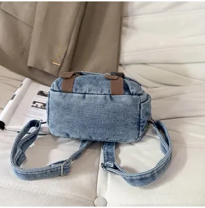 Gedetailleerd overzicht van een vintage gewassen denim rugzak met bruine banden en textuur.