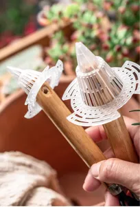 Close-up detail of plastic flower pot drainage mesh cover with wooden handle for gardening.
