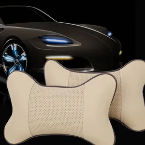 Pair of breathable beige leather car headrest pillows, ergonomic bone design for neck support.