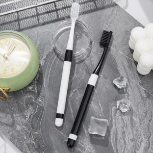 Lot de 2 brosses à dents souples pour adultes en noir et blanc pour les soins bucco-dentaires.