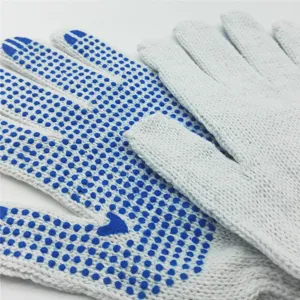 Gros plan de gants de protection antidérapants avec des points en PVC bleu sur fil de coton.