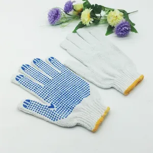 Vue détaillée de gants de travail en coton blanc avec paume antidérapante à pois bleus.