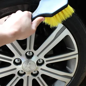 Car tire brush wheel cleaning tool with ergonomic black handle and durable yellow bristles for auto care.