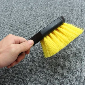 Car wheel cleaning brush detail, yellow stiff bristles with ergonomic black plastic handle.