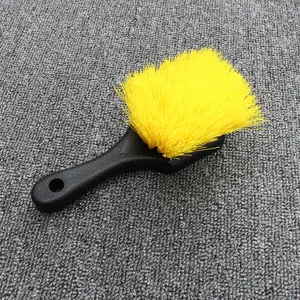 Close-up detail of the durable black handle and bright yellow bristle car cleaning brush.