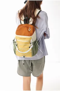 Backpack detail view showing color block design, front pocket print and elastic cords.