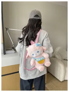 Detailed view of a cute pink plush sheep backpack featuring blue bow, vivid eyes and floral pocket.