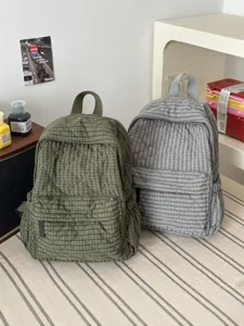 Detail view of casual quilted backpacks in olive green and grey check for women daily use.
