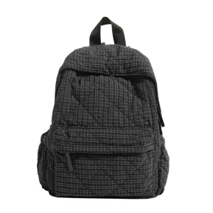 Black and white quilted grid backpack detail, showing fabric texture and pocket design.