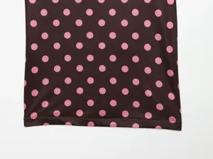 Polka dot fabric detail of women clothing, stylish brown and pink pattern with neat hem stitch.