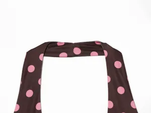 Detail shot of women halter neck top in brown with pink polka dots, stylish trendy fashion apparel.
