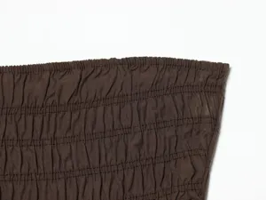 Primo piano del dettaglio del tessuto arricciato marrone alla moda, con texture elastica.