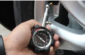 Nahaufnahme eines mechanischen Autoreifen-Luftdruckmessers mit Zifferblatt und Metall.
