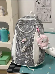 Detailansicht des schwarz-weißen Karierten Studentenrucksacks mit niedlicher Schleife und Plüsch.