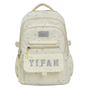 Nahaufnahme des süßen cremefarbenen Schulrucksacks mit silbernen Sternmustern und Buchstaben.