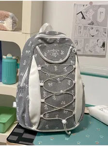 Detailansicht eines niedlichen schwarz-weißen Karo-Schulrucksacks mit Schleifen.