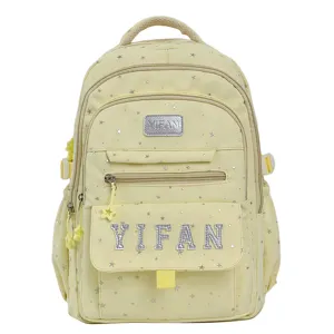 Detaillierte Ansicht des gelben Schulrucksacks mit silbernem Sternenmuster und Buchstaben.