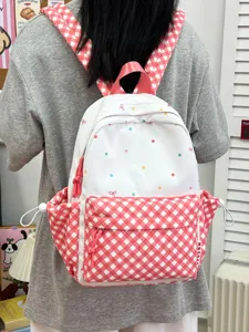 Rosa-weißer karierter Schulrucksack mit bunten Punkten und Schleifen für Schüler.