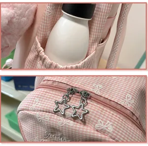 Rosa karierter Schulrucksack mit Schleifenstickerei und süßen Stern-Reißverschlüssen.