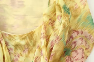 Close-up detail shot of a women's floral printed dress fabric, showing soft texture.
