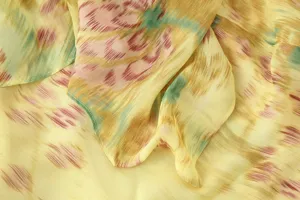 Detailed view of women's fashion floral printed dress fabric with elegant yellow tone.