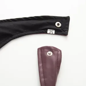 Close-up detail view of women apparel strap and metal snap button with size label.