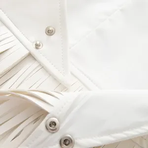 White women fashion fringe vest detail shot, stylish snap button design and fringe trim.