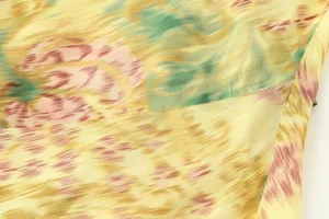 Abstract print dress fabric detail showing soft texture and stitching lines close up.