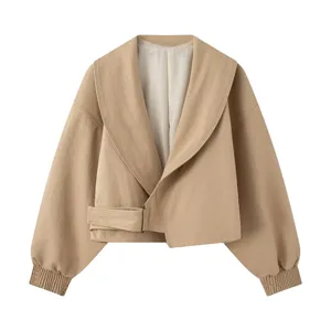 Detail view of stylish beige cropped jacket featuring wide lapel collar and waist belt buckle.